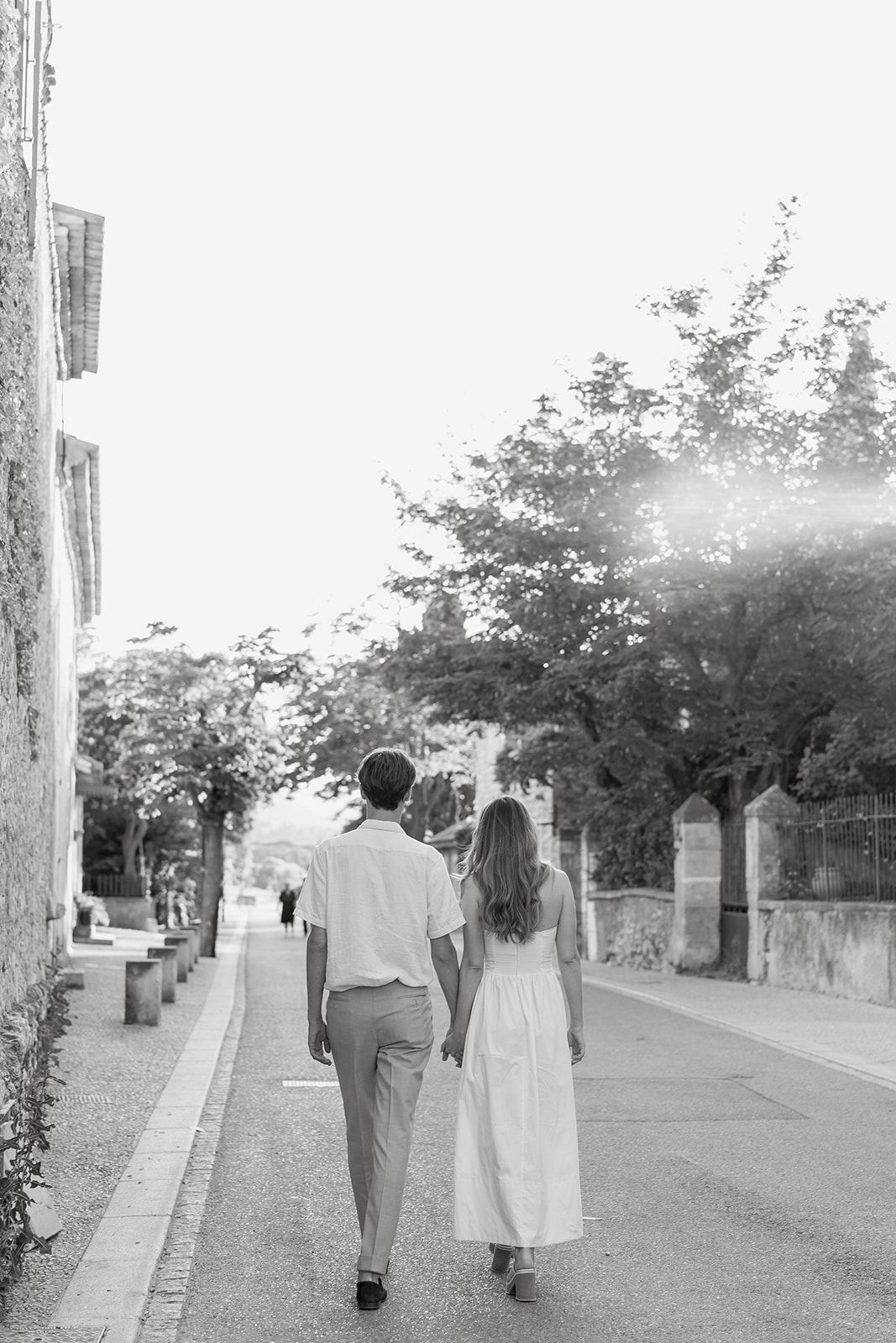 couple qui se promène main dans la main dans un village de Provence avant leur mariage